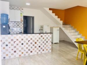 a kitchen with a counter and stairs in a room at Duplex Praia dourada in Maragogi