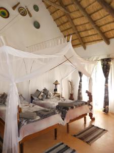 a bedroom with two beds with a canopy at Wild Dogs Lodge in Lusaka