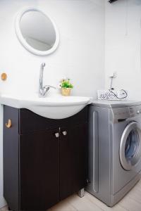 a bathroom with a sink and a washing machine at Apartment Happiness in Bat Yam