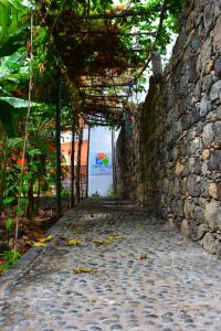 a stone wall with a walkway in front of it at Oasis Paul Residencial in Paul