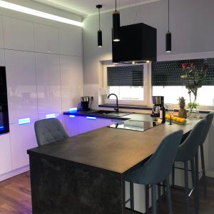 a kitchen with a large island in a kitchen with blue lights at Apartament w Cieplicach Perfekt in Jelenia Góra