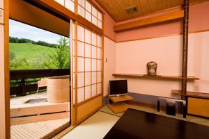 a living room with a large window and a television at Hotel Sunbird in Minakami