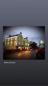 un gran edificio verde con luces en una calle en The Anvil Bar B&B en Castlemaine