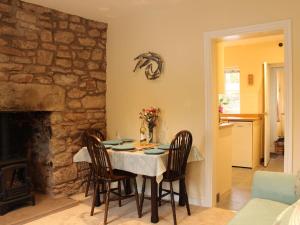 uma sala de jantar com mesa e cadeiras e uma parede de pedra em No 10 Dulas em Hay-on-Wye
