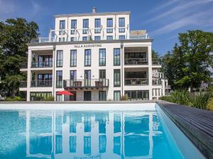 - un grand bâtiment blanc avec une piscine en face dans l'établissement Baltic Cloud*****, à Binz