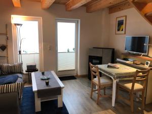 a living room with a couch and a table with chairs at Ein kleines Haus in Fehmarn