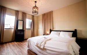 a bedroom with a white bed and a chandelier at 8 Boutique By The Sea in George Town