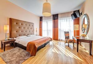 a bedroom with a large bed and a desk at Don Prestige Residence in Poznań