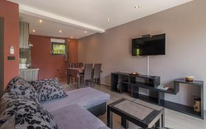 uma sala de estar com um sofá e uma televisão na parede em Apartmani Kažun - App 4 - Ferienhaus em Fažana