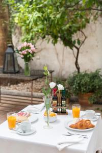 a white table with plates of food and orange juice at Hotel Alcántara in Seville