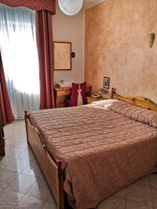 a bedroom with a bed and a desk and a window at Albergo Diana in Cerreto Laghi