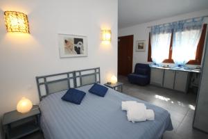 a bedroom with a blue bed and a blue chair at Poisson Rouge in Bonifacio