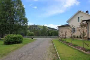 una casa con un vialetto di ghiaia accanto a una casa di Matkailumaja Heikkala Cottages a Ruka