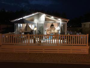 a small house with a deck at night at Southsea, Beach and Beauty Lodges in Portsmouth