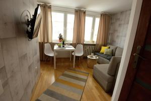 a living room with a couch and a table at Apartament Columbus in Ustrzyki Dolne