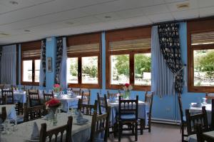 un comedor con mesas, sillas y ventanas en Hotel Garona, en Bossòst