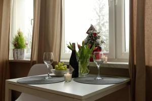 uma mesa com dois copos e uma taça de fruta e uma janela em Apartament Columbus em Ustrzyki Dolne