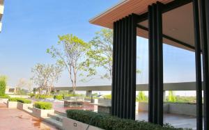 a building with large glass windows and a courtyard at The 21 MuangthongThani in Pak Kret