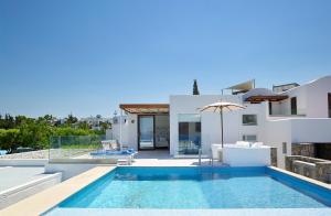 a villa with a swimming pool and a house at St. Nicolas Bay Resort Hotel & Villas in Agios Nikolaos