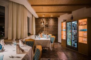 a dining room with tables and chairs and a wine cellar at Hotel Rodella in Selva di Val Gardena