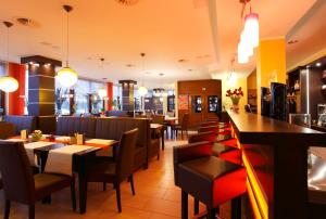 a restaurant with tables and chairs and a bar at Willmersdorfer Hof in Cottbus