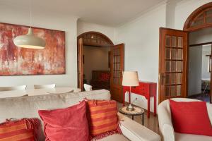 a living room with a couch and red pillows at Cascais Handsome Apartment in Cascais