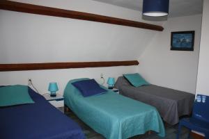 a bedroom with two beds and a blue chair at GRAND GITE RURAL in Salmiech