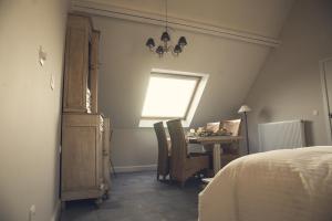 um quarto com uma cama, uma mesa e uma janela em B&B In de velden em Bocholt