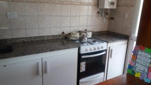 a kitchen with a stove and white cabinets at Casa Quinta Las Pintas in Olavarría +5 photos