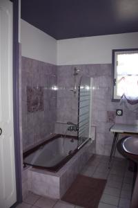 a bathroom with a bath tub and a sink at GRAND GITE RURAL in Salmiech