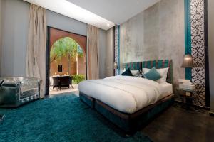 a bedroom with a bed and a room with a table at Residence Dar Lamia Marrakech in Dar Caïd Layadi