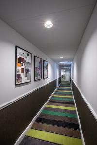 un couloir avec un long escalier orné de peintures sur les murs dans l'établissement Absalon Hotel, à Copenhague