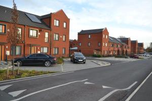 a car parked in a parking lot next to houses at Amersham Park Apartment in Manchester