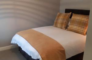 a bedroom with a bed with a brown and white blanket at The Masons Arms in Harrogate