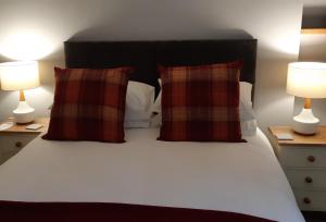 a bed with two pillows and two lamps on tables at The Masons Arms in Harrogate