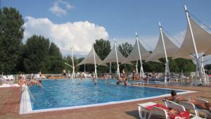 - une grande piscine avec des personnes à l'eau dans l'établissement NaturExpert Mobilházak-Füred Kemping Balatonfüred, à Balatonfüred
