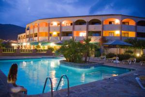 a hotel with a swimming pool in front of a building at Le California Motel in Sagone