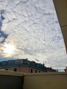 un ciel nuageux au-dessus d'un bâtiment avec toit dans l'établissement Cool & Central 2 bedroom in heart of Eaux-vives, à Genève
