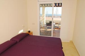 a bedroom with a bed and a view of the ocean at Residencial Marina de Port in L'Ametlla de Mar
