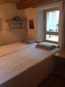 sypialnia z 2 łóżkami i oknem w obiekcie Rustico Cadrobi 20 w mieście San Vittore
