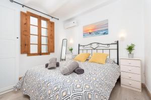 a bedroom with a large bed with yellow pillows at Casa Mercat in Pollença