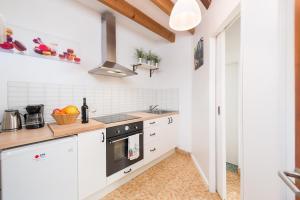 una cocina con armarios blancos y horno negro en Casa Mercat, en Pollensa