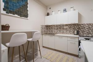 a kitchen with white cabinets and white stools at U svaté Ludmily in Litoměřice