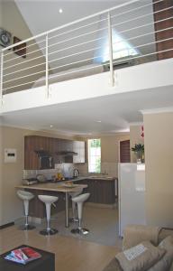 a kitchen with a counter and stools in a room at The Lofts in Polokwane