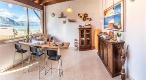 a room with a bar with chairs and a large window at SCIUSCIA' in Alcamo Marina