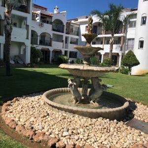 a fountain in front of a building with a statue of monkeys at La Siesta de Mijas Golf 174 in Fuengirola