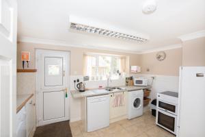 a kitchen with a sink and a dishwasher at Stable Cottage in Bardon Mill