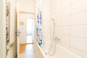 a white bathroom with a shower and a tub at Private apartments with direct subway entrance in Fürth