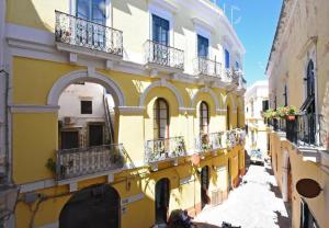un edificio amarillo con balcones en una calle en B&B Laura - Luxury Rooms, en Gallipoli