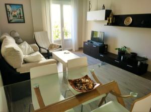 ein Wohnzimmer mit einem Glastisch und einem Sofa in der Unterkunft Apartamento Plaza Compañia Jerez in Jerez de la Frontera